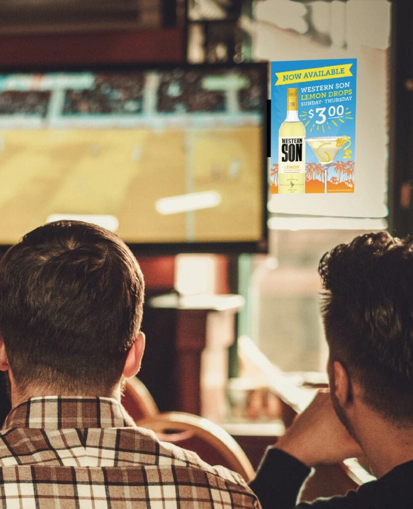 Two men are watching a game on a TV that has screen edge advertising on it.